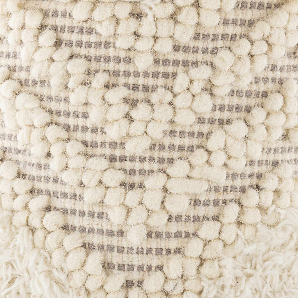 Close-up of textured beige pom pom stool