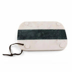 A rectangular marble serving board with rounded corners, featuring a dark green horizontal stripe across the center, four circular white pads on the underside, and a dark brown leather tie.