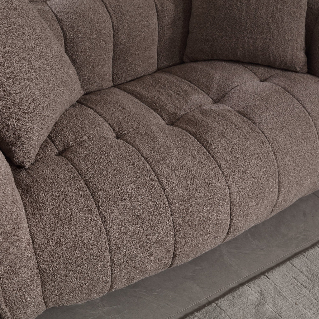 Close-up of a brown textured sofa with tufted design