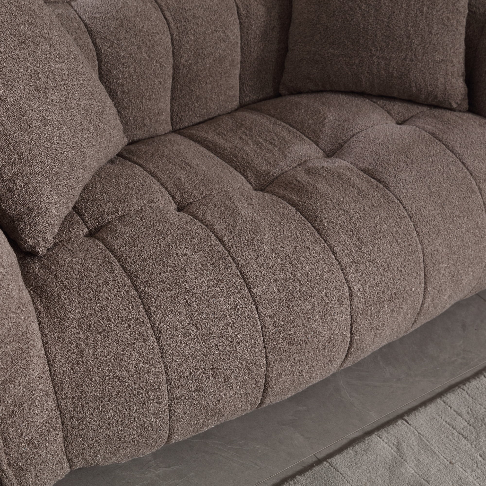Close-up of a brown textured sofa with tufted design