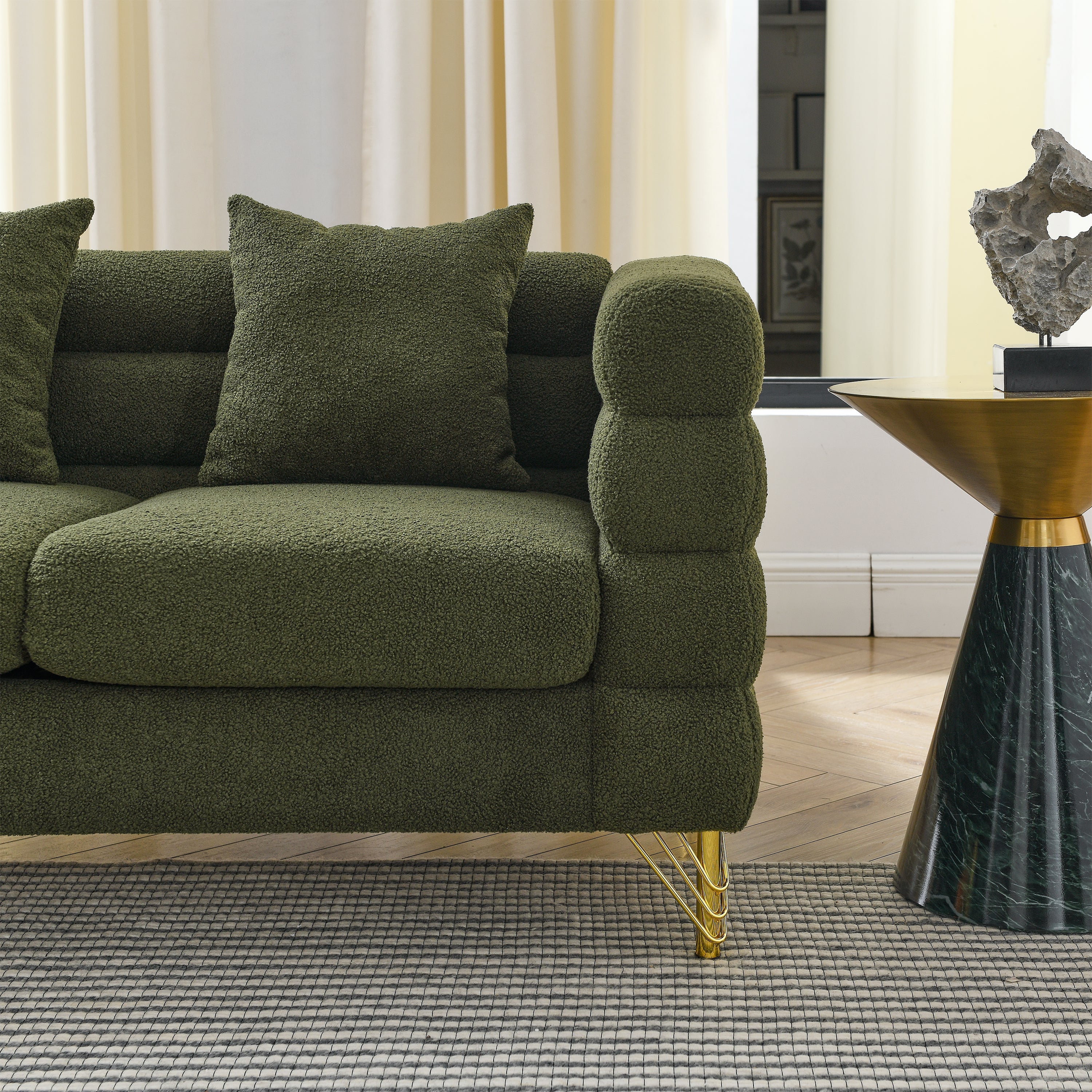 Green sofa with gold legs in a living room setting