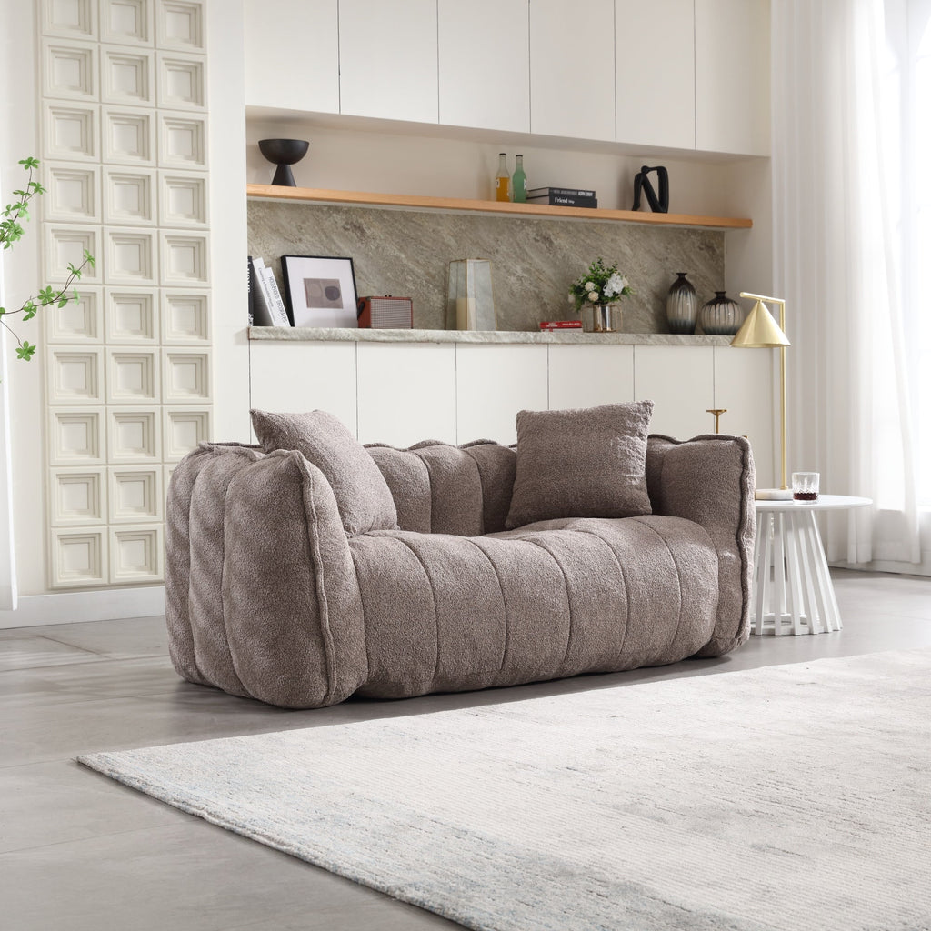 Brown sofa in a modern living room with shelves and decor.
