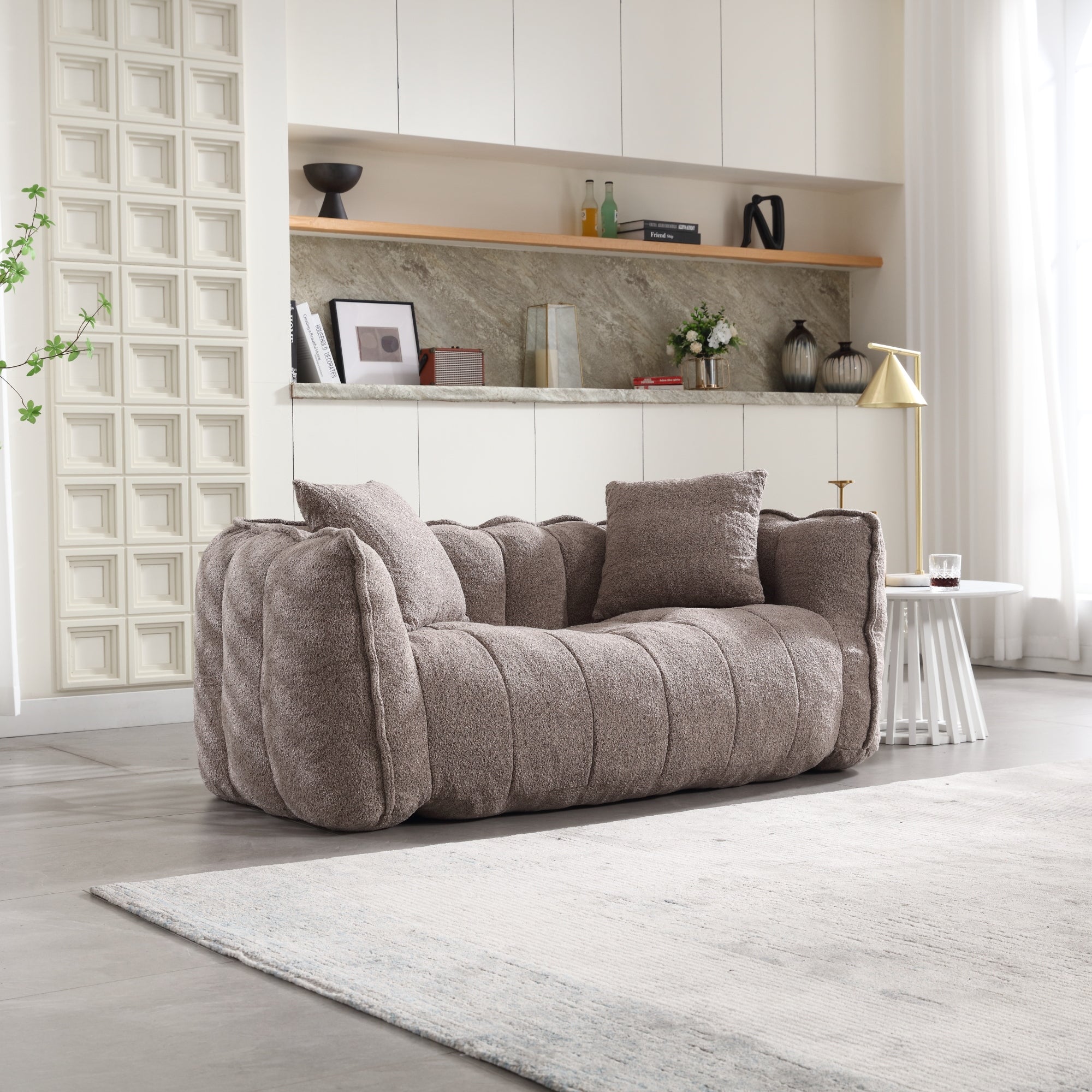 Brown sofa in a modern living room with shelves and decor.