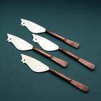 Set of four cheese knives with copper handles on a dark green background