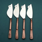 Four rat-shaped cheese knives with wooden handles on a teal background