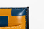 Close-up of a patchwork leather chair with blue and orange sections on a white background