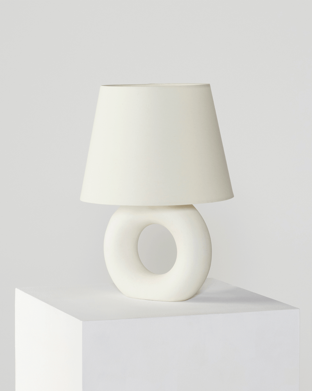 White table lamp with a unique base design on a light gray background