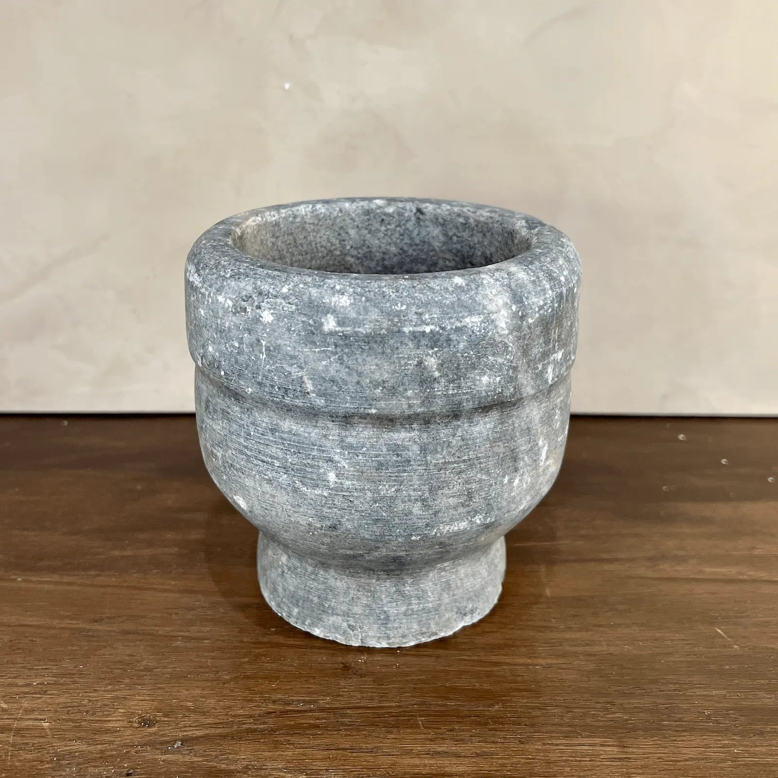 Stone mortar on a wooden surface with a neutral background