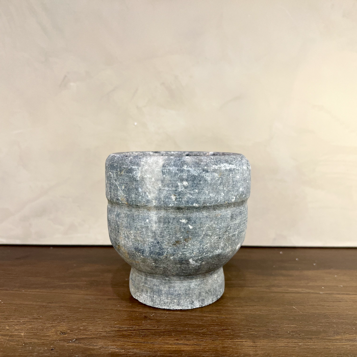 Marble-like stone bowl on a wooden surface with a neutral background