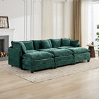 Green sectional sofa in a living room with wooden floor and white walls.