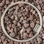 inside of a fire pit pot filled with small, brown rocks on a bed of similar rocks.
