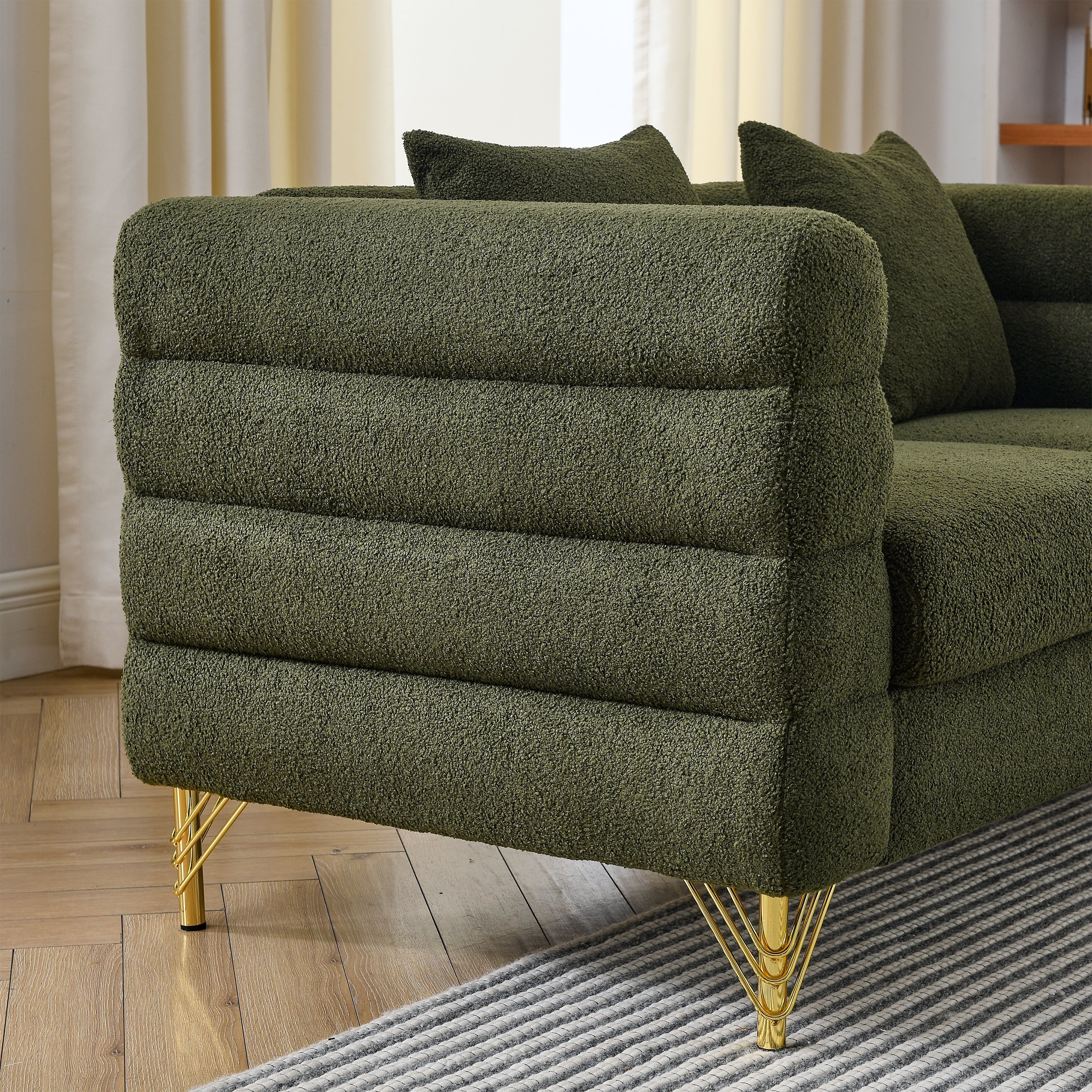Green textured sofa with gold legs in a living room setting