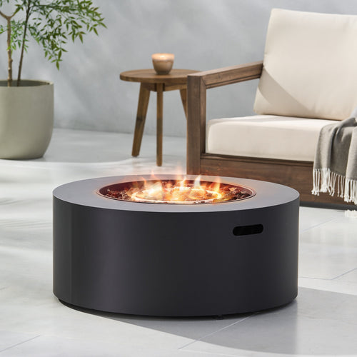 Black fire pit table with flames in a modern outdoor setting with a chair and table.