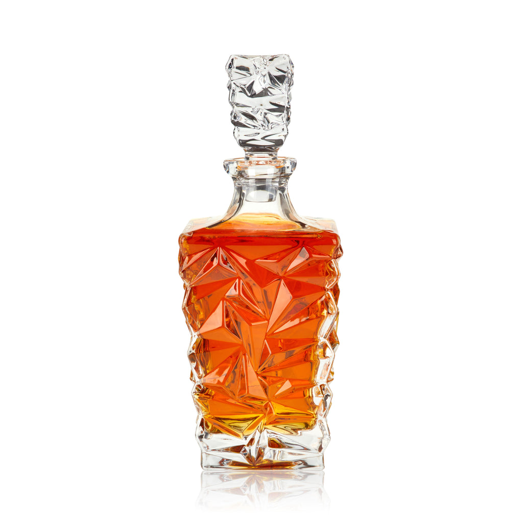 Decorative glass decanter with geometric design on a white background