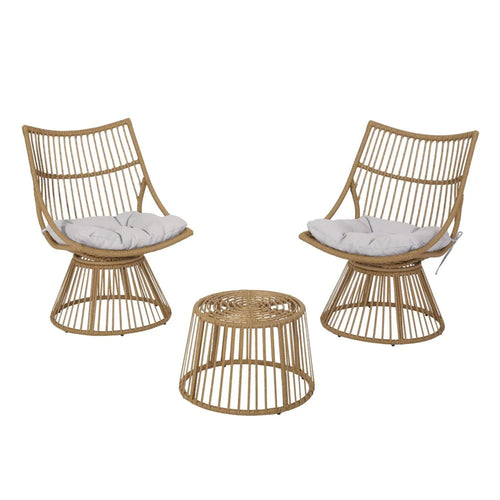 Two wicker chairs with white cushions and a matching wicker table on a white background