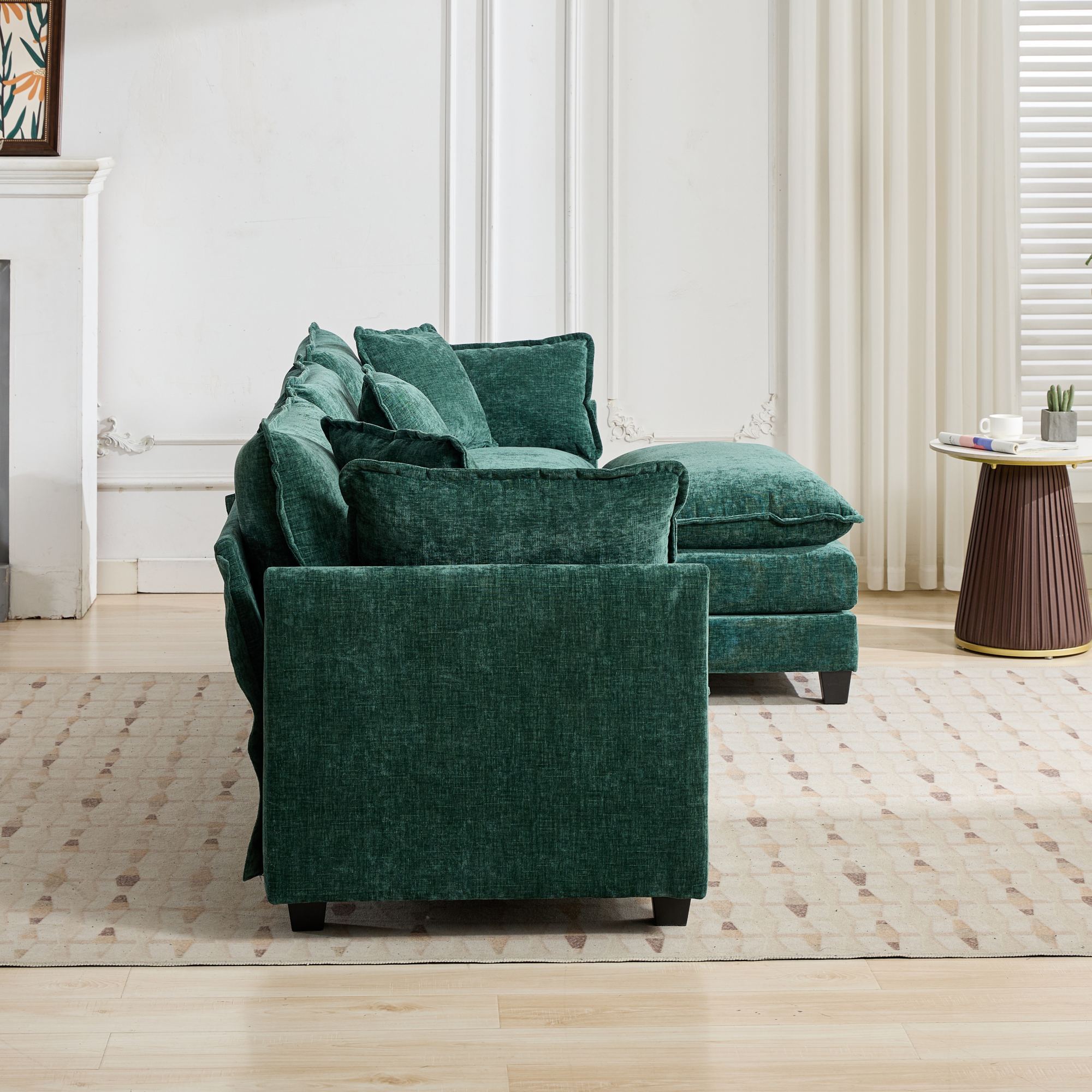 Green sofa in a living room setting with a side table and decor items.
