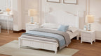 White bedroom set with bed, nightstands, and desk in a well-lit room.
