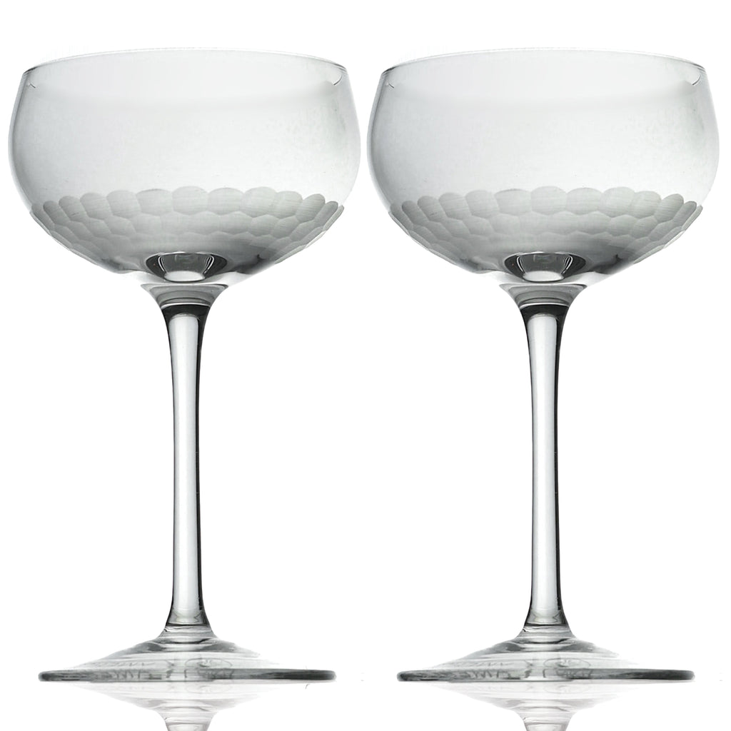 Two clear glass goblets with textured bases on a white background