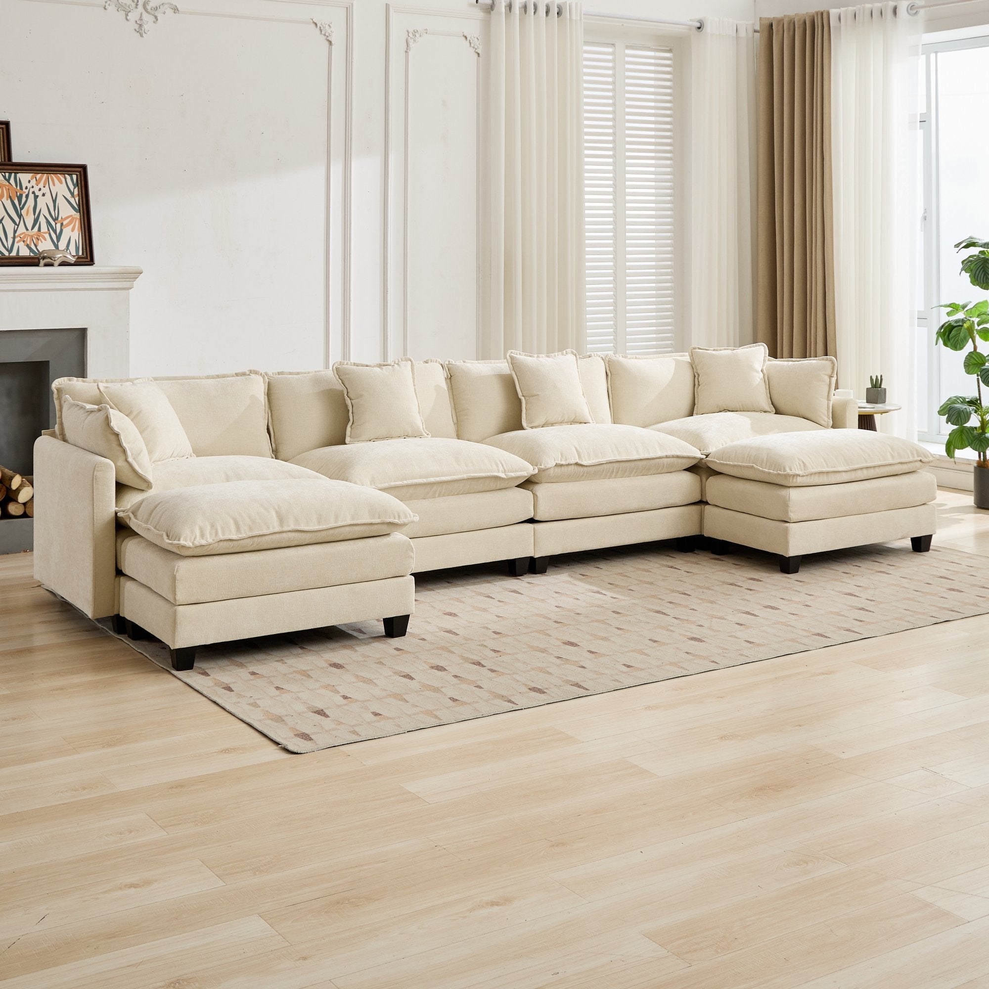 Beige sectional sofa in a living room with wooden floor and large windows.