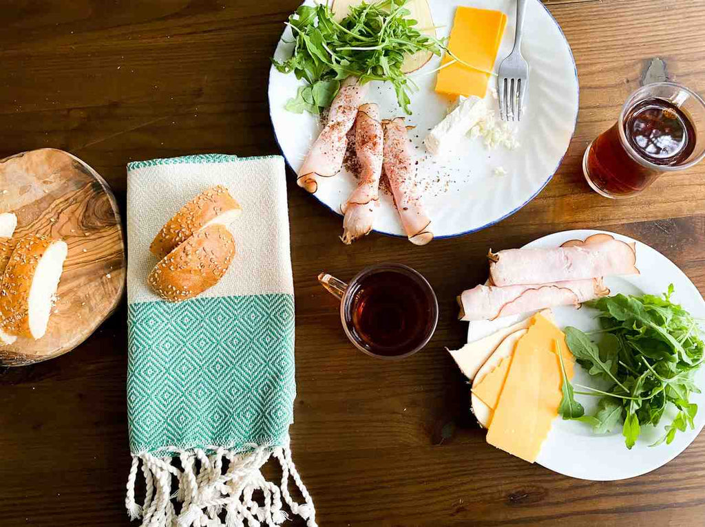 Eco-friendly Turkish tea guest towel with green geometric pattern, folded beside bread.