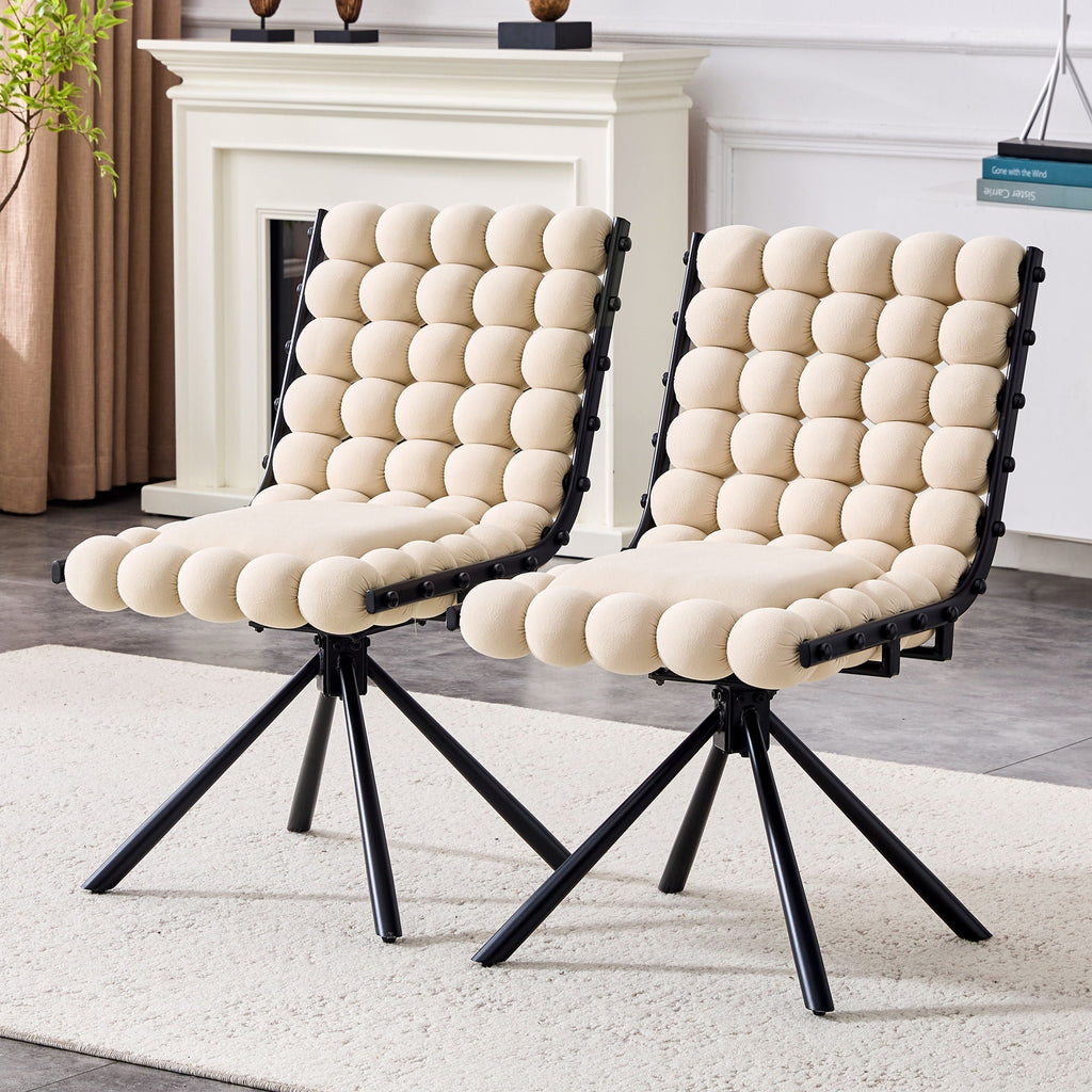 Two modern chairs with beige cushioned seats and black metal frames in a living room setting.