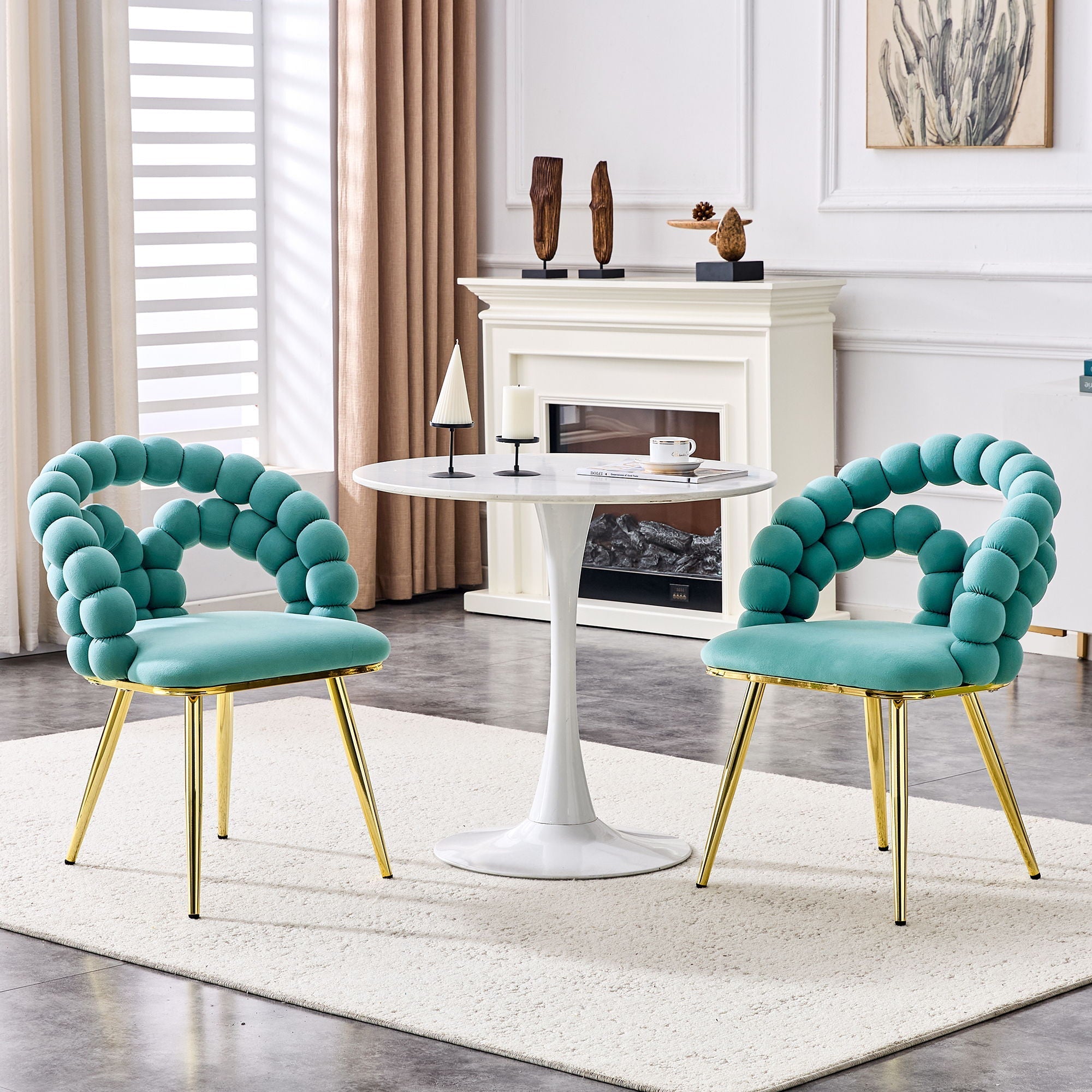 Two turquoise chairs with gold legs in a living room setting.