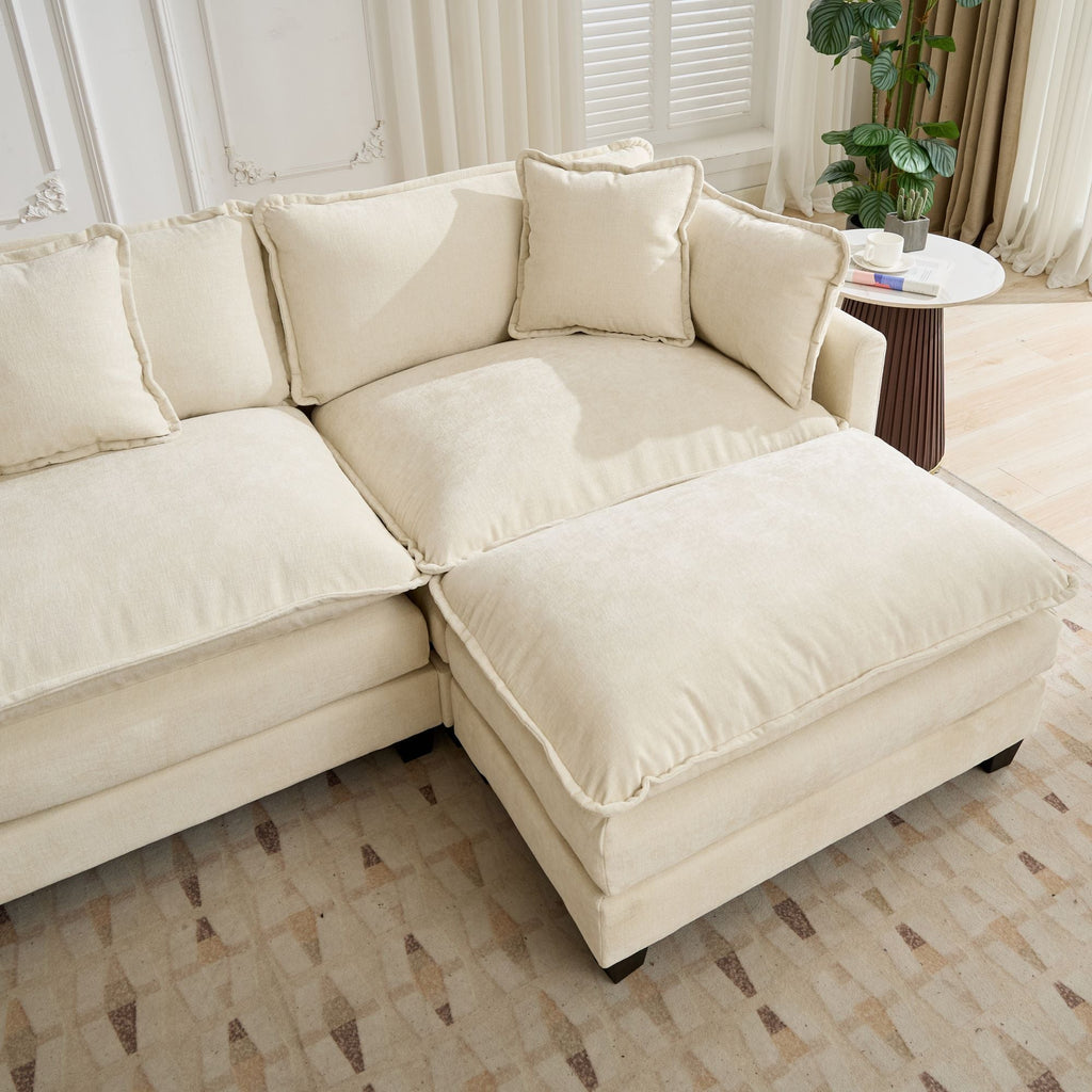 Beige sectional sofa in a living room setting with a small table and plant.