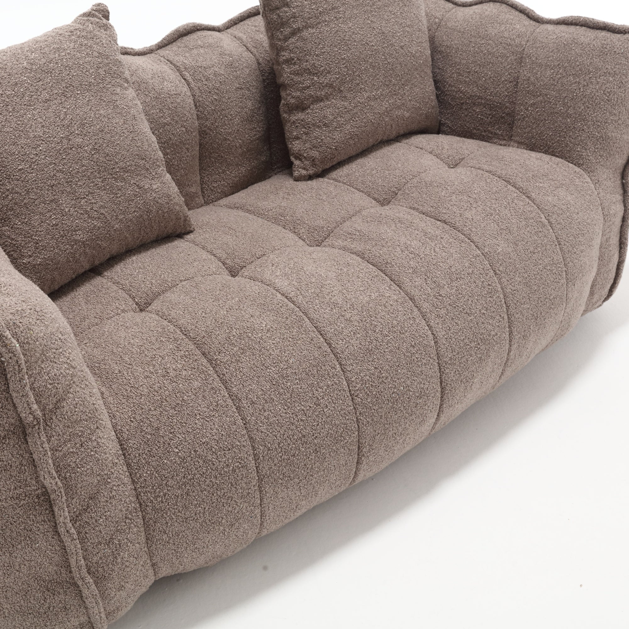 Brown textured sofa with cushions on a white background