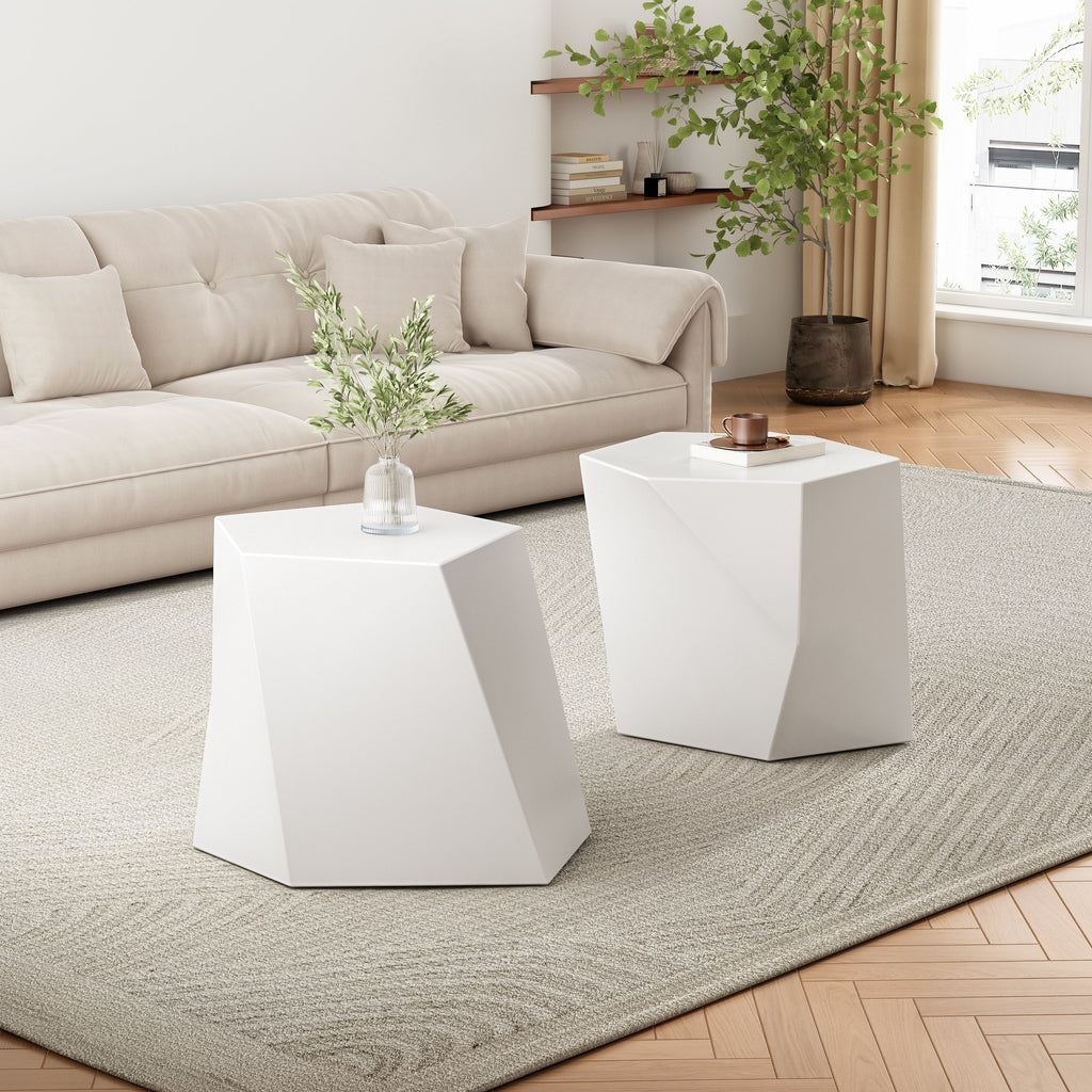 Two white geometric side tables in a living room with a beige sofa and decorative items.