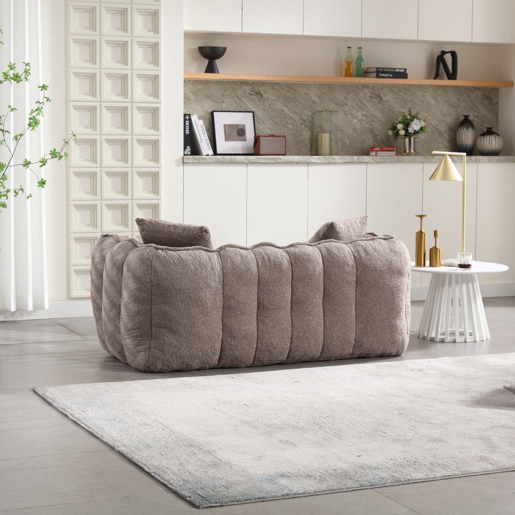 Gray sofa in a modern living room with shelves and decor.