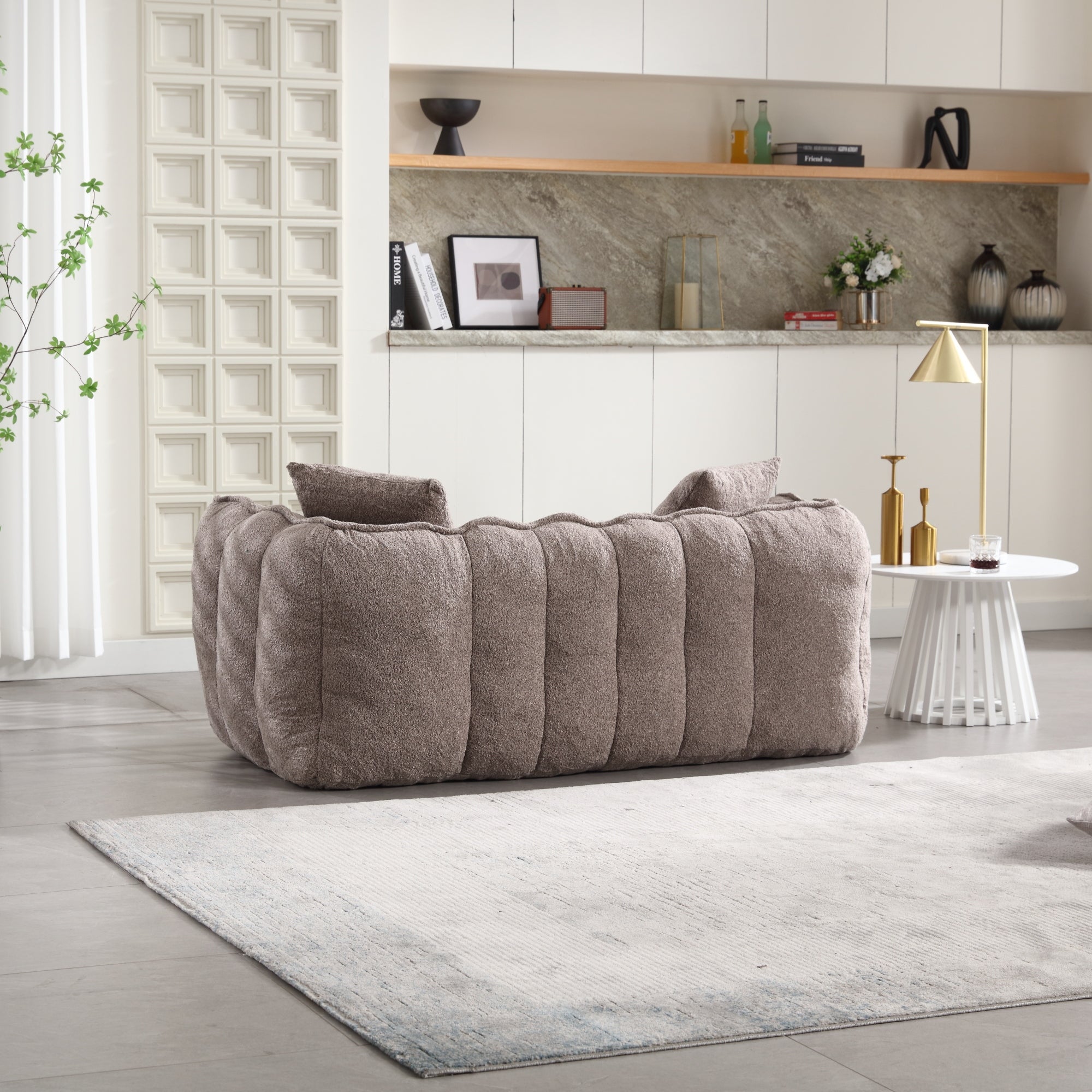 Gray sofa in a modern living room with shelves and decor.
