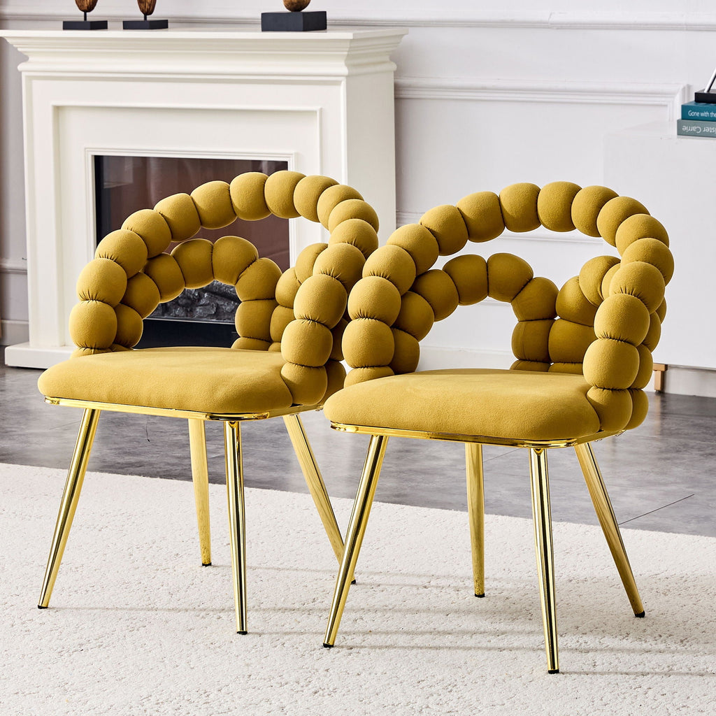 Two mustard yellow chairs with unique circular backrests in a room with a fireplace.