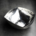 Silver bowl with a textured surface on a dark background