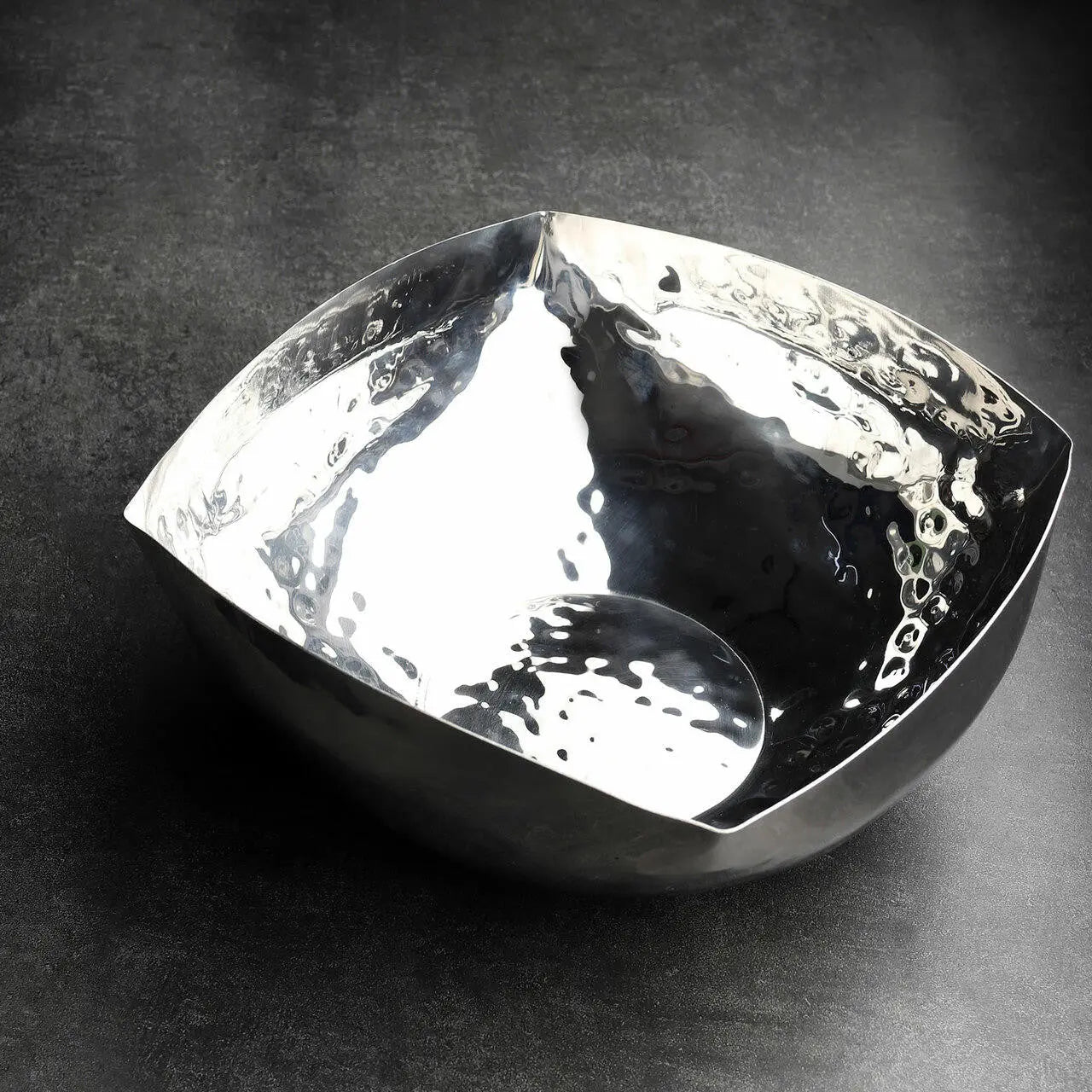 Silver bowl with a textured surface on a dark background