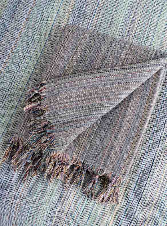 Folded gray king size blanket with tassel fringe, textured woven pattern, home decor