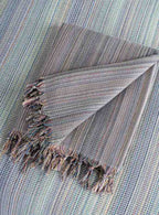Folded gray king size blanket with tassel fringe, textured woven pattern, home decor