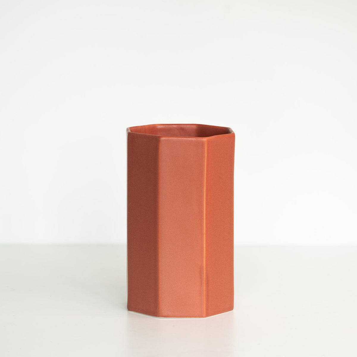 Hexagonal terracotta vase on a light gray background