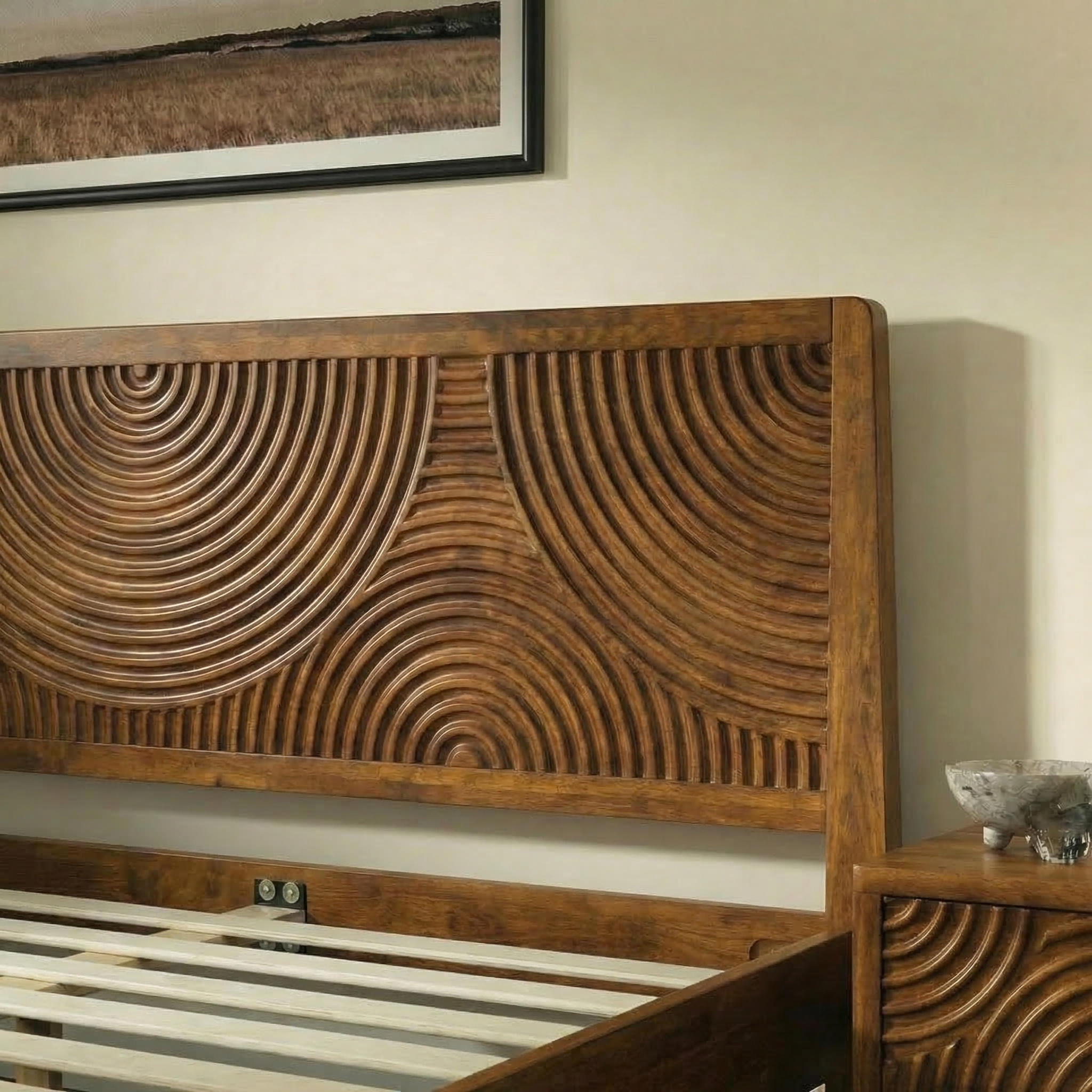 Wooden bed with intricate carvings on a neutral wall.