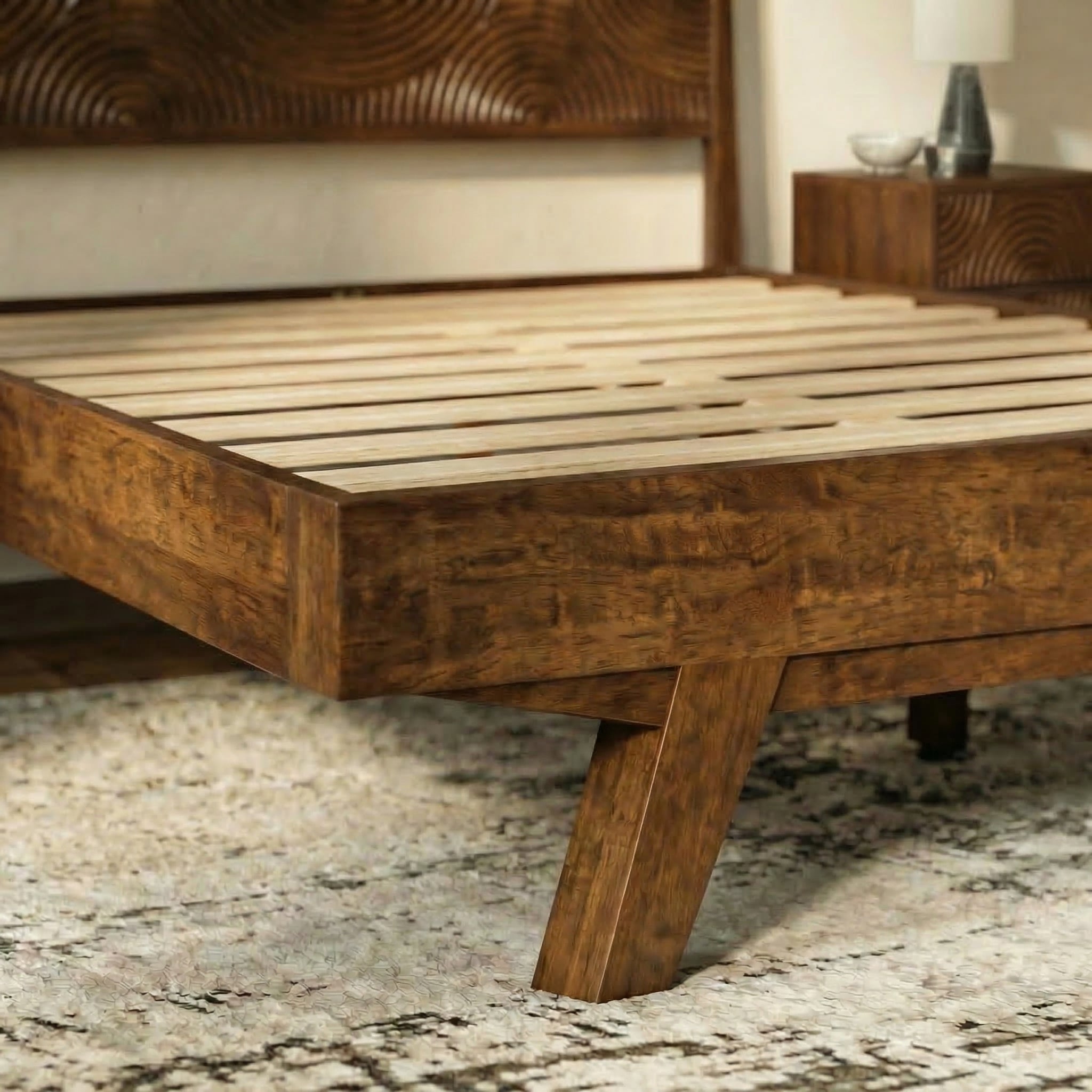 Wooden bed frame with a textured headboard in a bedroom setting.