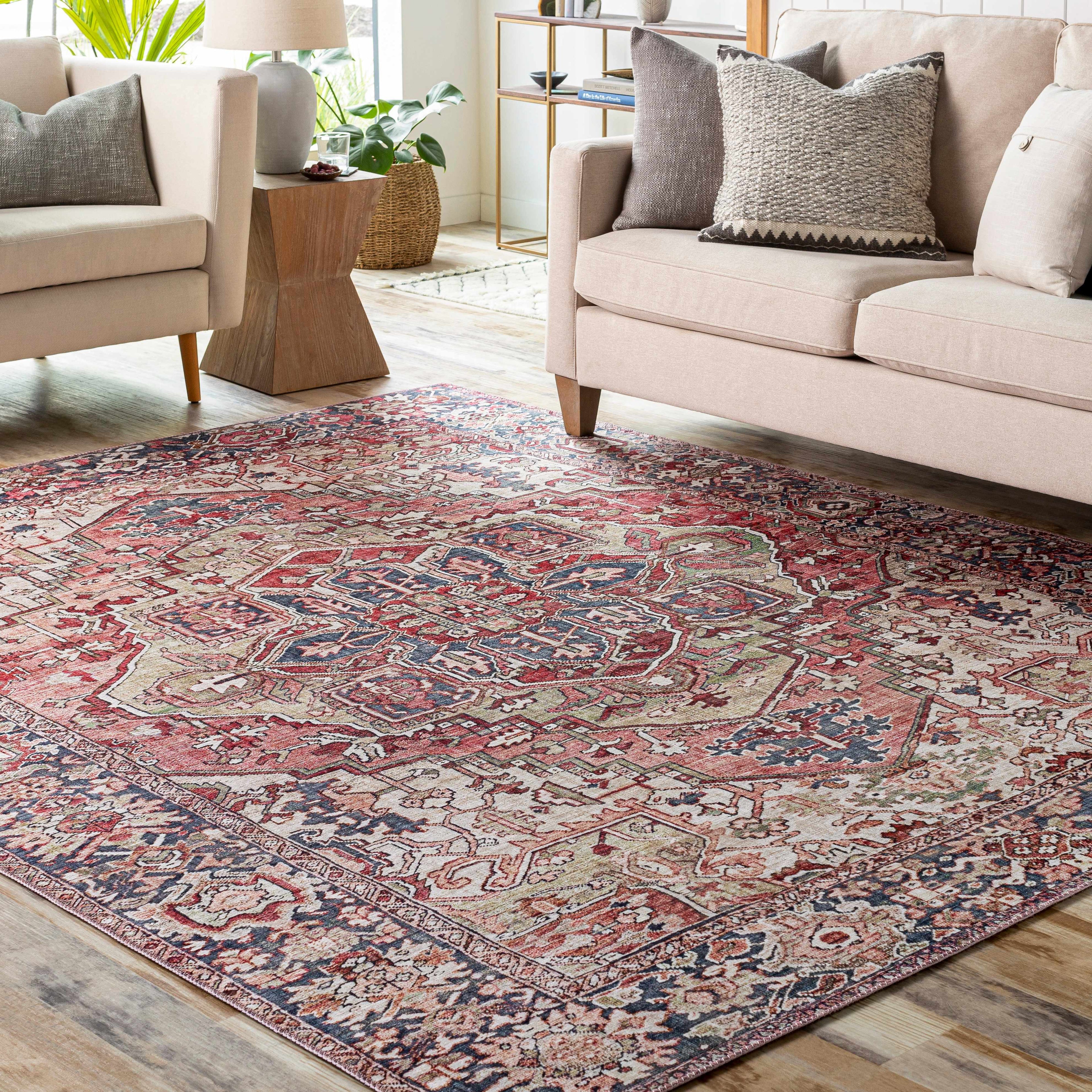 Patterned rug in a living room with beige sofas and decor pillows.