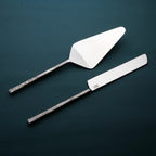 Two metal spatulas with a white spatula on top on a white background