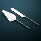 Two metal cake knives on a dark background