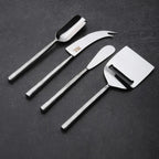 Set of four metal cheese tools on a dark surface