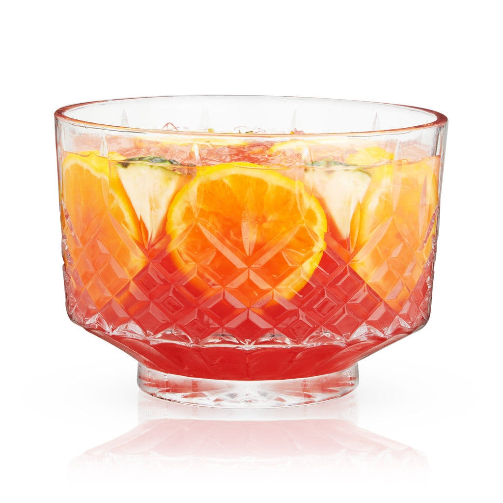 Clear glass bowl filled with a colorful fruit salad on a white background