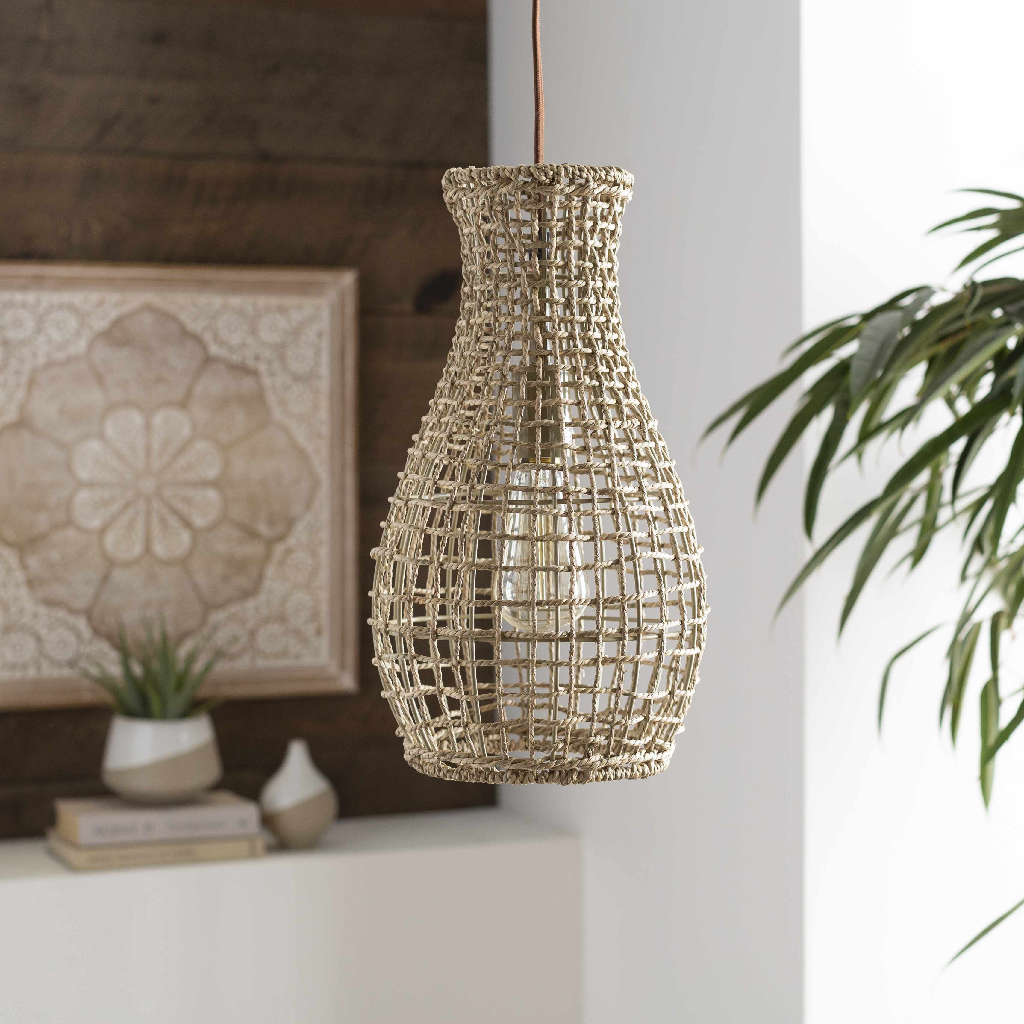 Woven pendant light turned off hanging in a room with decor elements.