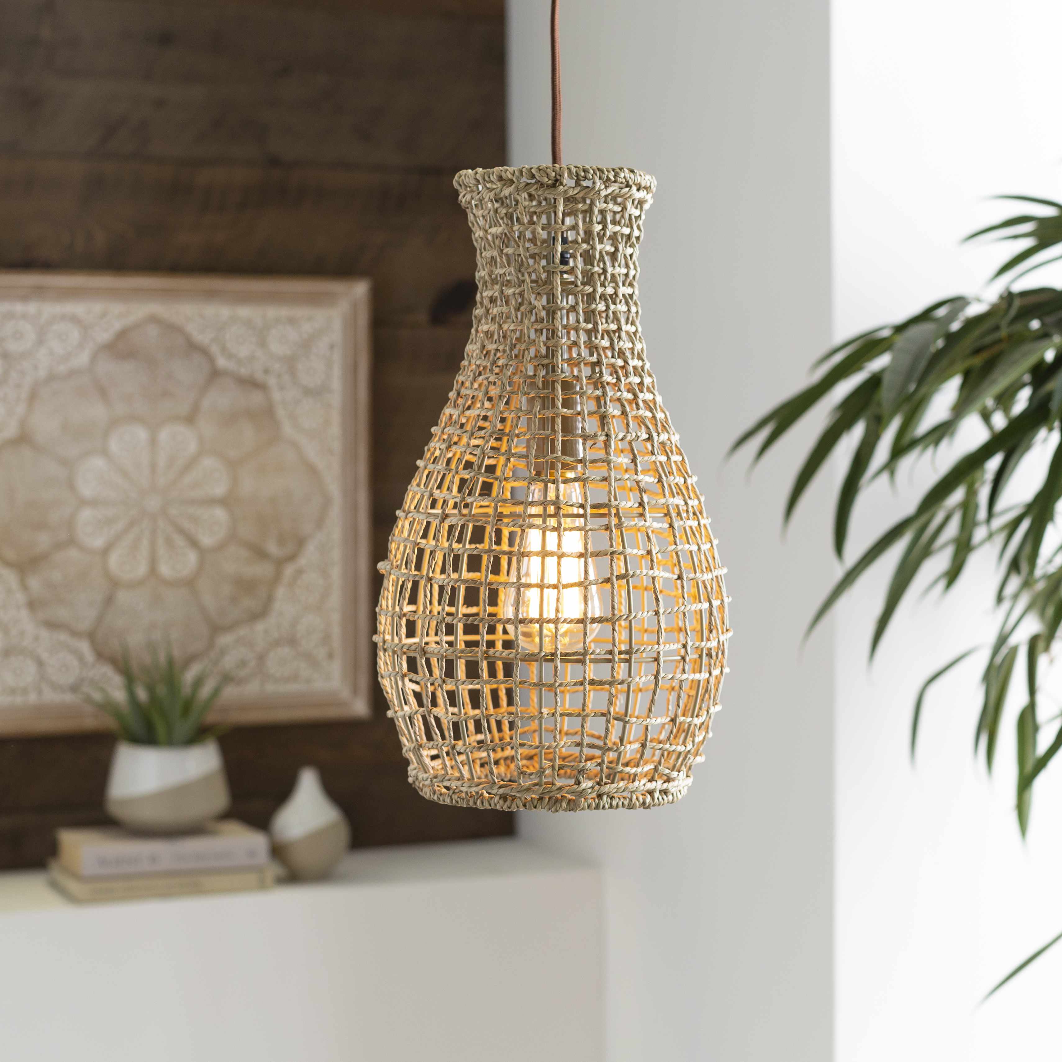 Woven rattan pendant light hanging in a room with decor elements.