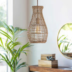 Woven pendant light hanging in a room with a plant and books on a table.