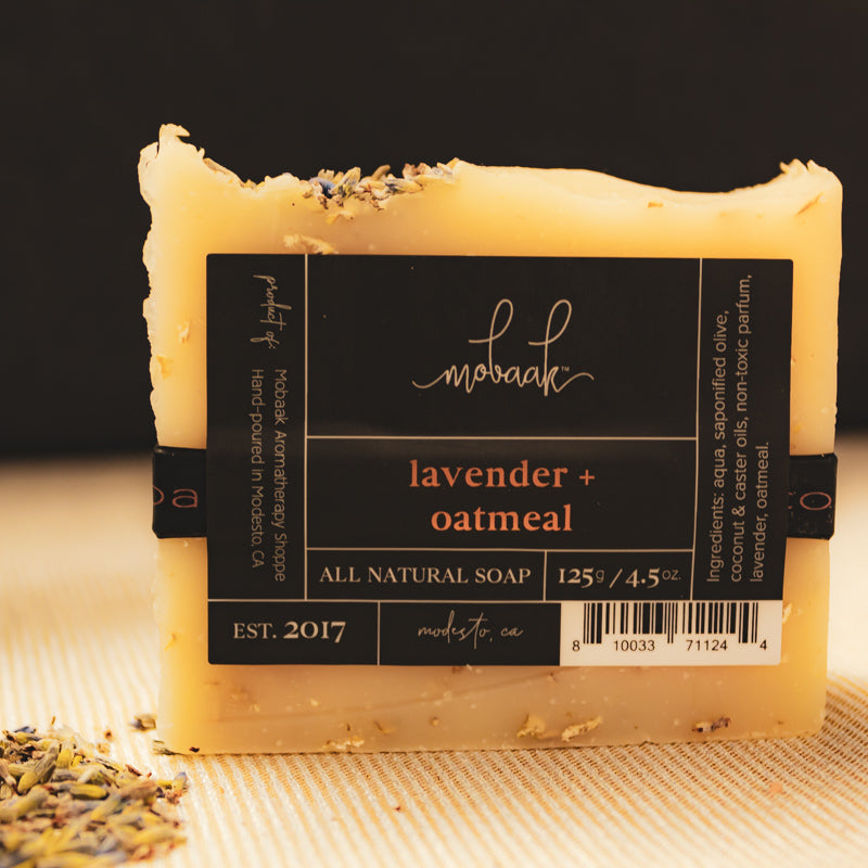 All natural soap bar with lavender and oatmeal on a textured surface, featuring the brand 'mokach'.