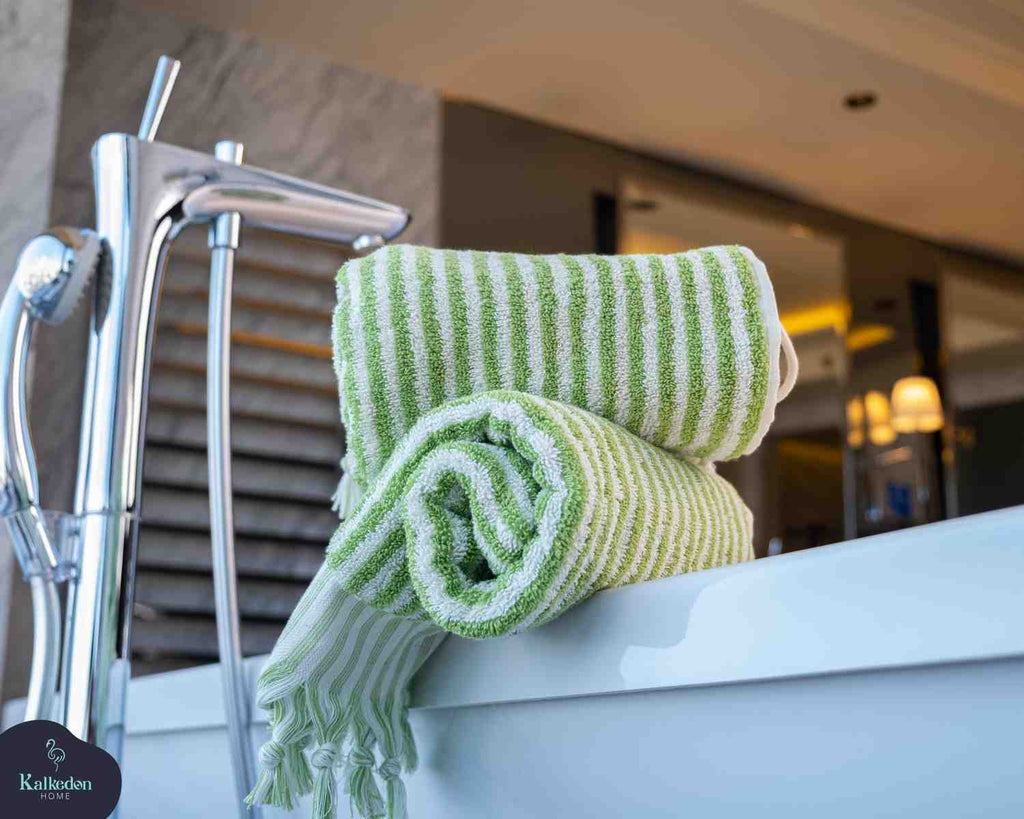 folded lime green striped hand towels on bathtub in modern bathroom