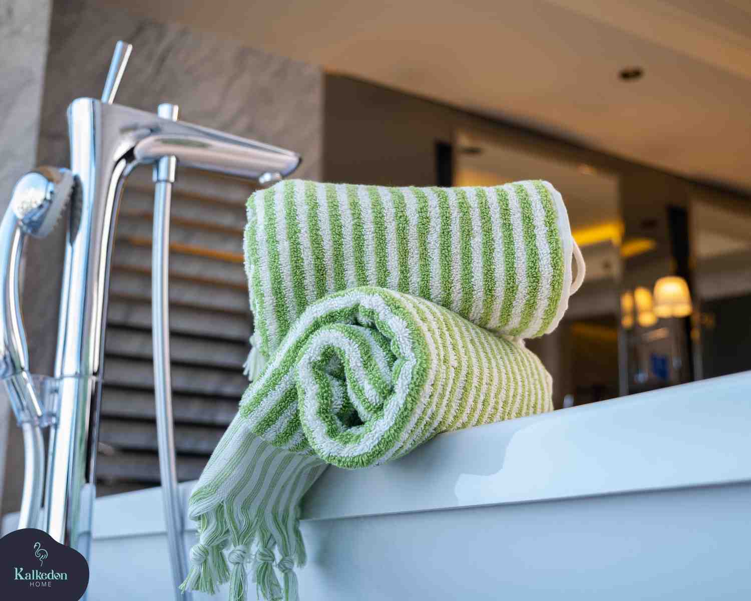 folded lime green striped hand towels on bathtub in modern bathroom